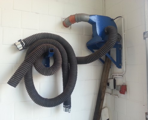 Schlauch der Abgasabsaugung an der Wand