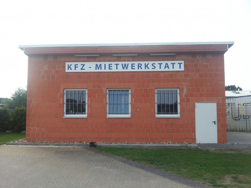 Außenansicht der KFZ-Mietwerkstatt, Klinkerbau mit Schriftzug